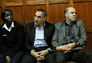 a Kenyan policewoman accompanies Iranian nationals Sayed Mansour Mousavi, center, and Ahmad Abolfathi Mohammad, right
