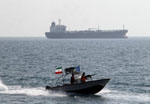 Iranian Revolutionary Guards drive a speedboat in front of an oil tanker at the port of Bandar Abbas