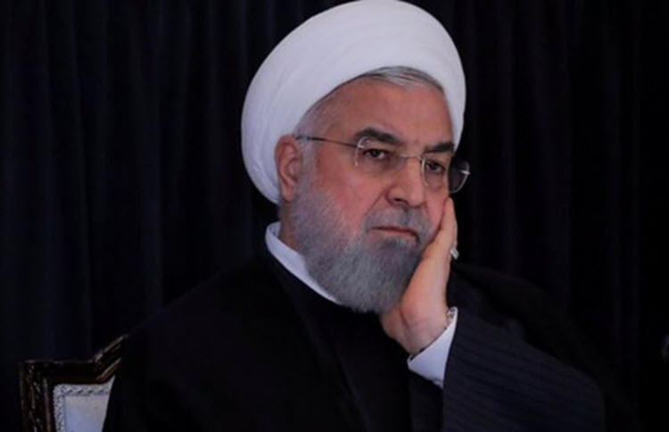 Iranian President Hassan Rouhani with head in hands
