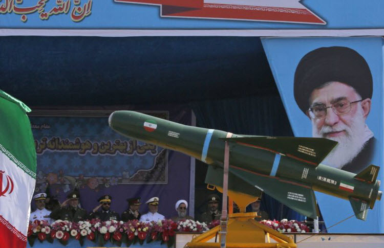 An Iranian military truck carries missiles past a portrait of Iran's Supreme Leader Ayatollah Ali Khamenei