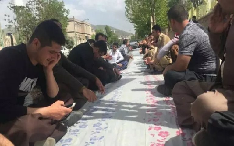 Symbolic protest of Iranian workers sitting on an empty tablecloth, to show their miserable situation.